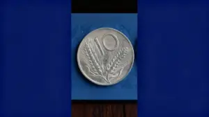 Moneta italiana da 10 Lire con spighe di grano su sfondo blu.