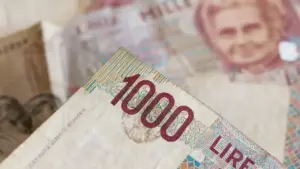 Dettaglio di una banconota italiana da 1000 lire con volto femminile sullo sfondo