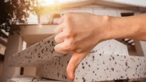 Mano che mostra pollice verso davanti a pannelli isolanti in polistirolo