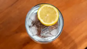 Bicchiere di acqua con ghiaccio e fetta di limone vista dall'alto