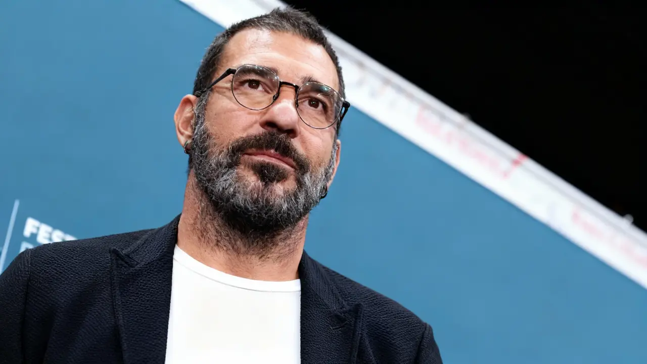 Una persona alla Festa del Cinema di Roma con sfondo blu e occhiali