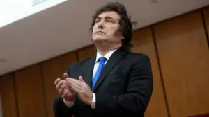 Persona in abito scuro con cravatta blu in un ambiente formale