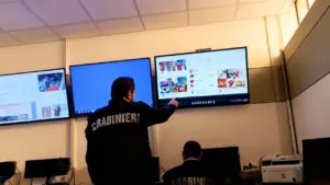 Due agenti dei Carabinieri analizzano contenuti su uno schermo in una sala operativa