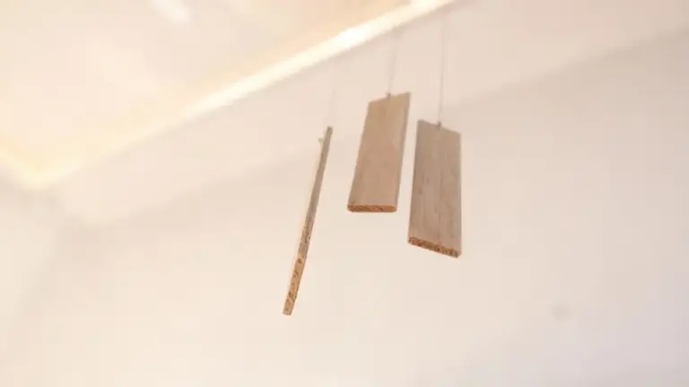 Tre pannelli di legno sospesi in aria in uno spazio neutro