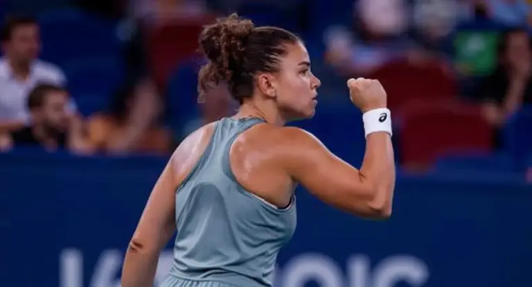 Tennista in campo esulta con il pugno chiuso durante un match