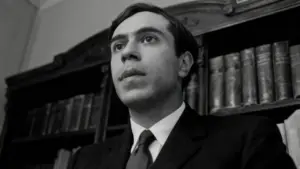 Una persona giovane in abito formale davanti a una libreria antica