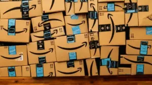 Numerosi pacchi Amazon impilati su una superficie di legno