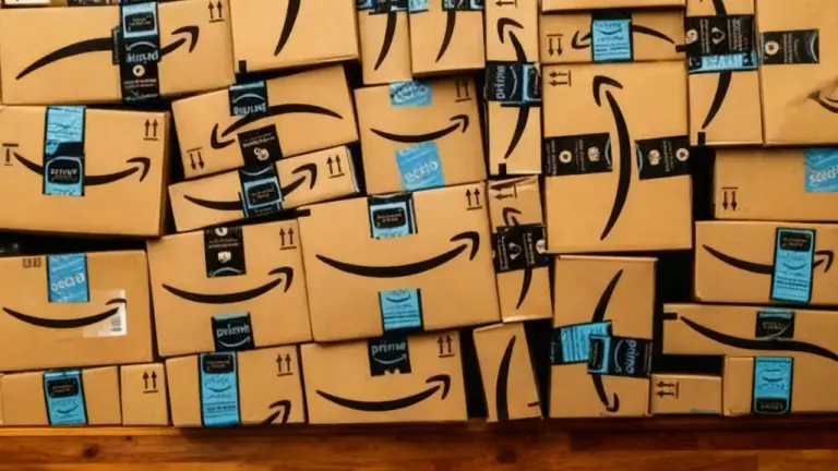 Numerosi pacchi Amazon impilati su una superficie di legno