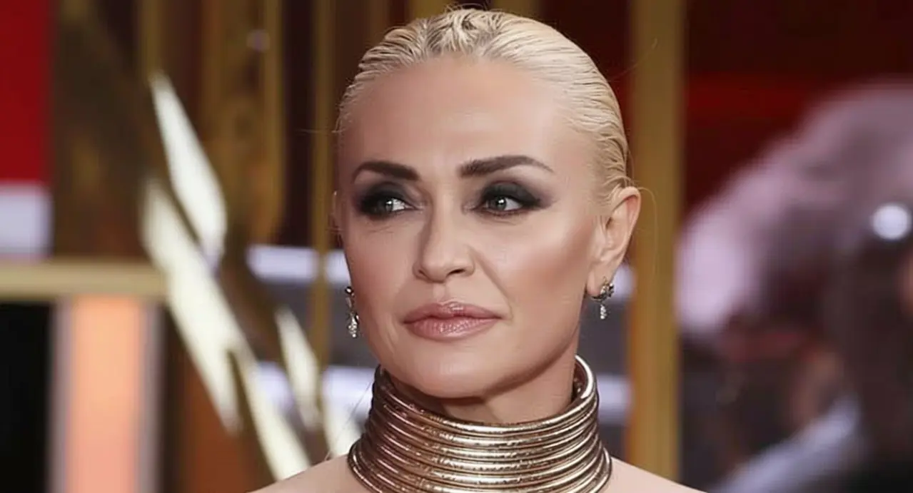 Una donna con capelli biondi raccolti e trucco marcato in un ambiente elegante