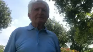 Anziano all'aperto in una giornata soleggiata, circondato da alberi