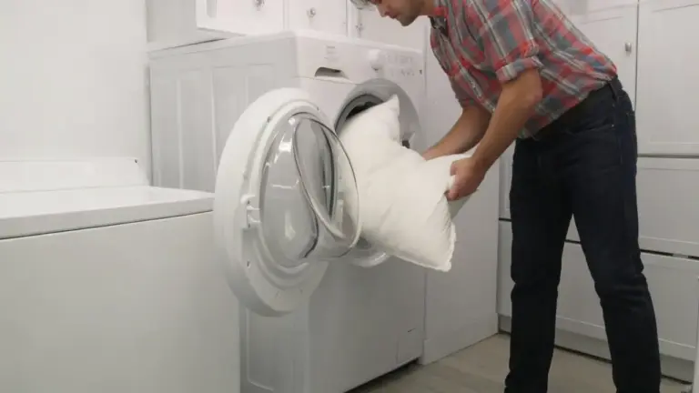 Persona che inserisce un cuscino in lavatrice in una lavanderia domestica