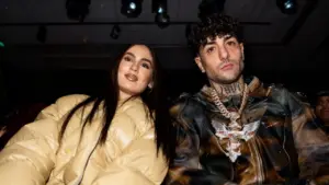 Due persone sedute una accanto all'altra durante un evento al chiuso