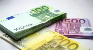 Mazzi di banconote da 100, 200 e 500 euro su una superficie chiara