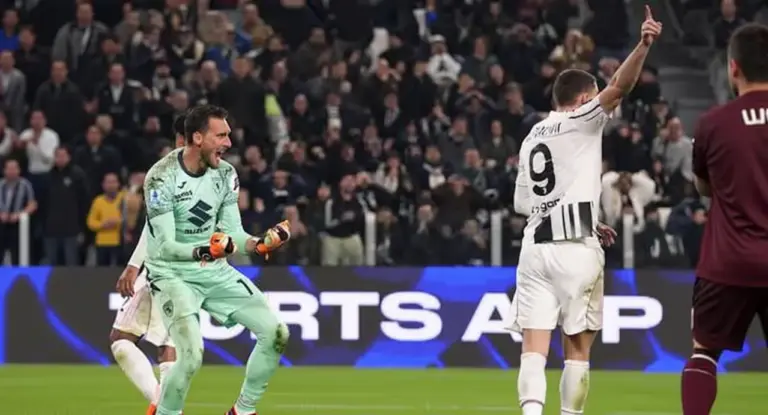 Un portiere esulta in campo durante una partita con un attaccante che alza il braccio