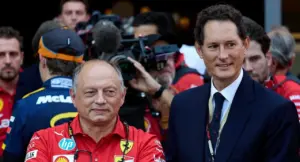 Due uomini nel paddock della Formula 1, uno in abbigliamento Ferrari e l'altro in abito formale