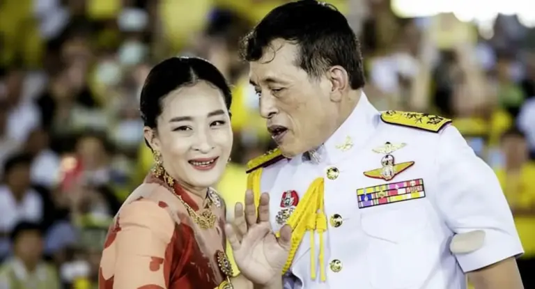 Un uomo in uniforme militare bianca accanto a una donna in abito tradizionale sorridente