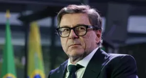 Un uomo in abito formale con occhiali in un contesto istituzionale